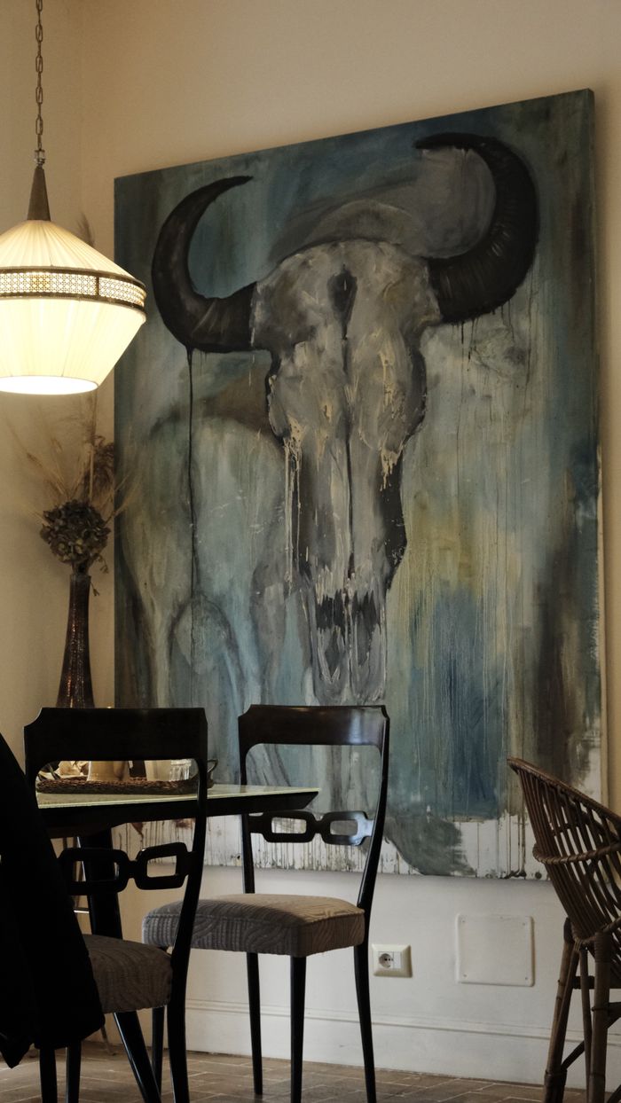Contemporary dining room featuring abstract bull skull painting.